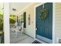Inviting front porch with rocking chairs and a teal front door adorned with a wreath, exuding a welcoming atmosphere at 214 Blackstone Dr, Moncks Corner, SC 29461