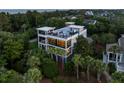 Stunning modern home with multiple balconies, a rooftop deck, and surrounded by lush greenery at 2213 Rolling Dune Rd, Seabrook Island, SC 29455