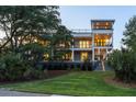 Charming three-story home with multiple balconies, lush landscaping, and a well-manicured lawn at 2213 Rolling Dune Rd, Seabrook Island, SC 29455