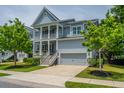 Charming two-story home featuring double porches, a grey garage door, and manicured landscaping at 2234 Mother Of Pearl Dr, Mount Pleasant, SC 29466