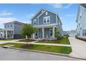 Charming two-story blue home boasts a welcoming front porch and well-manicured lawn at 238 Bird Song Path, Summerville, SC 29485