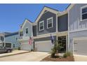 Beautiful townhome exterior showcasing garages and charming architectural details, with both US and state flags displayed at 2648 Balena Dr, Mount Pleasant, SC 29466