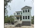 A two-story home on pilings with pale siding and a white porch railing at 2790 Burden Creek Rd, Johns Island, SC 29455