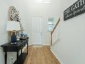 Inviting entryway with wood floors, stylish decor, and a view of the staircase and front door at 297 Red Leaf Blvd, Moncks Corner, SC 29461