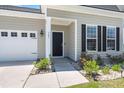 Inviting home exterior showcasing a two-car garage, manicured lawn, and charming front entryway at 341 Witch Hazel St, Summerville, SC 29486