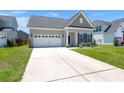 A well-kept single-Gathering home with a two-car garage, a tidy lawn, and tasteful landscaping at 341 Witch Hazel St, Summerville, SC 29486
