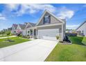 Inviting home with a long driveway leading to a two-car garage and charming front porch at 413 Eagleview Dr, Moncks Corner, SC 29461