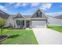 Charming home with a manicured lawn, covered porch, and a two-car garage at 413 Eagleview Dr, Moncks Corner, SC 29461