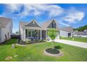 Beautiful home featuring a well-manicured lawn and a quaint front porch with seating at 413 Eagleview Dr, Moncks Corner, SC 29461