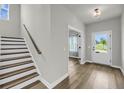 Inviting foyer with wood-look floors, staircase, and natural light streaming through the front door at 4308 Cotton Flt Rd, Summerville, SC 29485