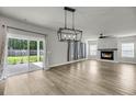 Bright living room with a fireplace, modern chandelier, and sliding glass doors to the patio at 4308 Cotton Flt Rd, Summerville, SC 29485