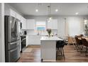 Bright, open kitchen with white cabinets, stainless appliances, and a central island with bar seating at 513 Donnas View Way, Summerville, SC 29486