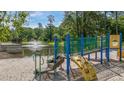 Colorful community playground with a whimsical design near a scenic pond at 7945 Parklane Ct # C, North Charleston, SC 29418