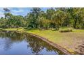 A serene community pond with a bench surrounded by lush trees and green grass at 7945 Parklane Ct # C, North Charleston, SC 29418