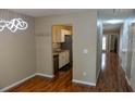 Well-lit dining room with modern lighting fixture, hardwood floors, and an open view to the kitchen and hallway at 7947 Vermont Rd, North Charleston, SC 29418