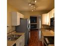 Efficient kitchen featuring stainless steel appliances, updated cabinets, and views into the living room with fireplace at 7947 Vermont Rd, North Charleston, SC 29418