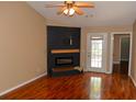 Cozy living room featuring a modern fireplace, wood floors, natural light, and access to an outdoor patio at 7947 Vermont Rd, North Charleston, SC 29418