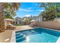 Backyard oasis with a sparkling pool, wooden deck, lounge chairs, and lush landscaping at 80 Smith St, Charleston, SC 29401