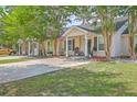 Charming home featuring an inviting front porch, a well-maintained yard, and ample parking space at 8028 Vermont Rd, North Charleston, SC 29418