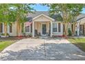 Inviting single-story home with an American flag, cozy front porch, and well-maintained landscape at 8028 Vermont Rd, North Charleston, SC 29418