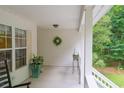 Welcoming porch features white railings, neutral walls and trim, and views of the surrounding greenery at 8346 Chisolm Plantation Rd, Edisto Island, SC 29438