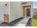 Inviting front entry showcasing stone accents, a sleek black door, and manicured landscaping at 9923 Honeylocust Ln, Ladson, SC 29456