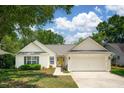 Attractive single-story home featuring a bright yellow front door, white siding, attached garage, and well-manicured lawn at 1027 Wayfarer Ln, Charleston, SC 29412