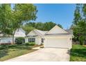 Attractive single-story home featuring white siding, attached garage, well-manicured lawn and paved driveway at 1027 Wayfarer Ln, Charleston, SC 29412