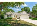 Attractive single-story home featuring a bright yellow front door, white siding, attached garage, and well-manicured lawn at 1027 Wayfarer Ln, Charleston, SC 29412