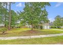 Expansive front yard with large trees shading the home's facade and offering curb appeal at 1042 Cobblestone Blvd, Summerville, SC 29486
