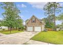 View of the home's two-car garage, driveway, and landscaped front yard lined with mature trees at 1042 Cobblestone Blvd, Summerville, SC 29486