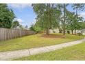 A view of the home's side yard showcasing the grassy expanse, sidewalk, and partial view of the house at 1042 Cobblestone Blvd, Summerville, SC 29486