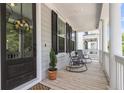 Inviting front porch featuring rocking chairs, columns, and a decorative floral wreath at 1093 Ave Of Oaks, Charleston, SC 29407
