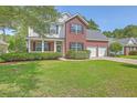 Attractive two-story home with a lush green lawn and established landscaping at 111 Kapalua Run, Summerville, SC 29483