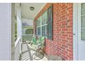 Cozy front porch featuring outdoor seating and brick accents at 111 Kapalua Run, Summerville, SC 29483
