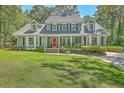 Inviting two-story home featuring a covered porch, neat lawn, and traditional architectural details at 121 Woodland Dr, Summerville, SC 29485