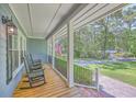 Cozy covered porch with rocking chairs, offering a relaxing outdoor space with a neighborhood view at 121 Woodland Dr, Summerville, SC 29485