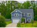 Charming two-story home with blue siding, white trim, well-kept lawn, and attached garage at 1387 Thin Pine Dr, Johns Island, SC 29455