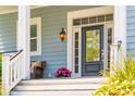 Cozy front porch with seating, decorative plants, and a view of the beautifully landscaped yard at 1446 Crane Creek Dr, Mount Pleasant, SC 29466