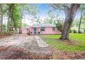 View of the exterior featuring a charming single story pink home surrounded by mature trees at 1514 Patterson Ave, Charleston, SC 29412