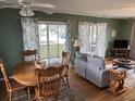 Inviting living and dining area features hardwood floors, neutral sofa, and screened porch access at 1736 E Ashley Ave, Folly Beach, SC 29439