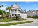 Inviting two-story home featuring a charming double porch, manicured lawn, and two-car garage at 203 Yeamans Way, Summerville, SC 29483