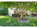Charming townhome with lush front lawn with mature trees and shrubbery, with long driveway and sidewalk at 215 Jackson St, Goose Creek, SC 29445