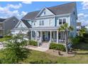 Charming two-story home with a welcoming front porch, landscaping and mature trees at 2917 River Vista Way, Mount Pleasant, SC 29466