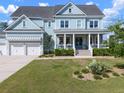 Charming two-story home with a welcoming front porch and a nicely landscaped front yard with palm trees and shrubs at 2917 River Vista Way, Mount Pleasant, SC 29466