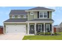 Attractive two-story home with a covered porch, well-kept lawn, and a two-car garage at 302 Lucca Dr, Summerville, SC 29486