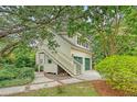 Unique two-story garage with exterior staircase surrounded by mature trees and landscaping at 312 Hobcaw Dr, Mount Pleasant, SC 29464