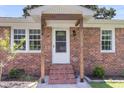 Inviting front entrance with brick steps, wooden support columns, and a decorative screen door at 334 Water Oak Dr, Goose Creek, SC 29445