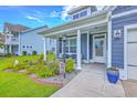 Charming front porch with blue siding and flower garden, perfect for relaxing in the neighborhood at 359 Whispering Breeze Ln, Summerville, SC 29486