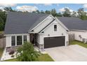 Beautiful single-Gathering home featuring gray vinyl siding, stone accents, dark garage door, and manicured landscaping at 404 Omaha Dr, Moncks Corner, SC 29461